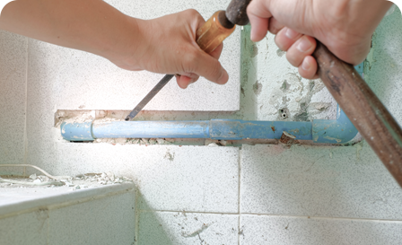 A person using a pair of scissors to cut the wall.