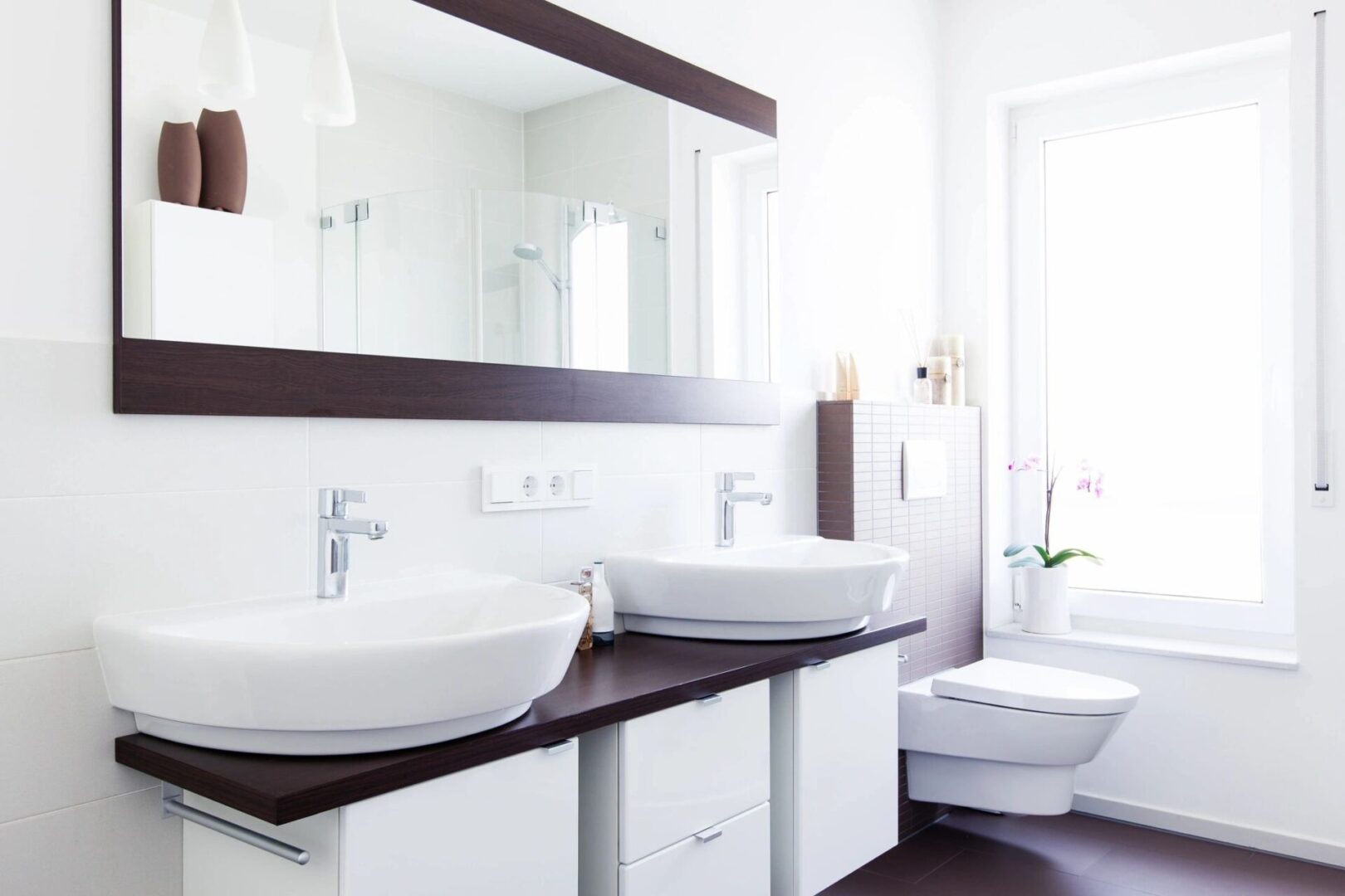 A bathroom with two sinks and a large mirror.