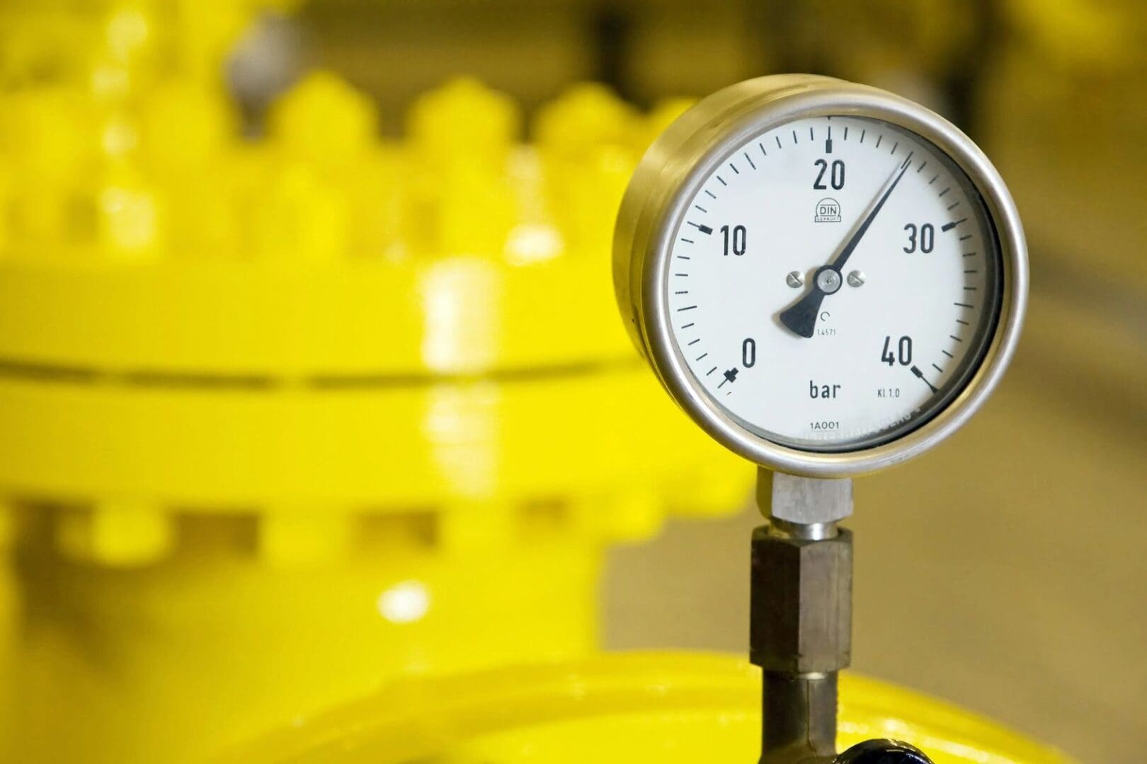 A close up of a pressure gauge on top of a yellow table.