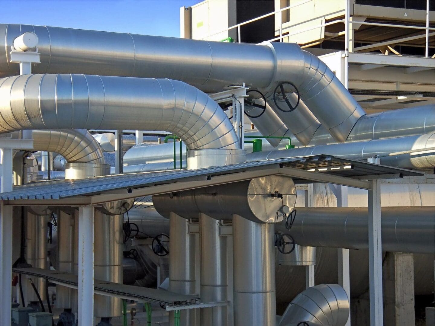 A large metal pipe system in front of a building.