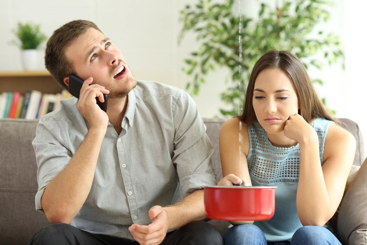 A man on the phone and woman in front of a red bowl.